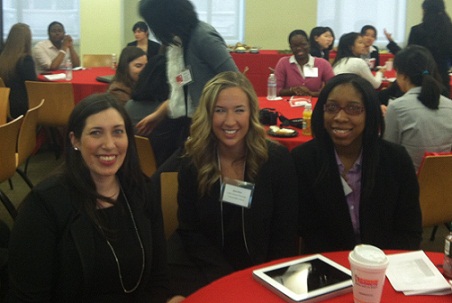 Three students sitting at table at conference