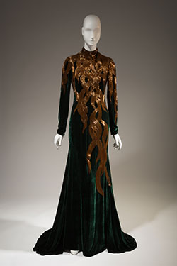 dark green velvet long sleeves evening gown with hand beaded amber-gold bugle beads in a falling hair tresses pattern at upper dress fading to nothing at hem