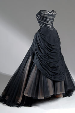 strapless black ballgown with sweeping trained full skirt with layers of black, beige, and brown net gathered into back bustle roll