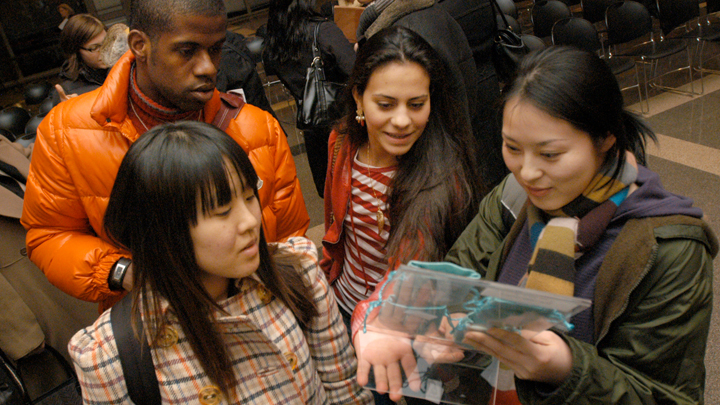 students looking at a woven item