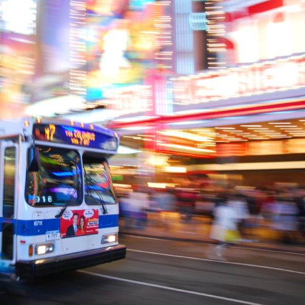 New York City bus. In the background of a blur or city lights