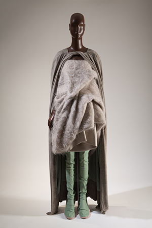 Ensemble of green pants with a long, beige mohair tunic and a taupe floor-length cape
