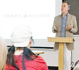 Tommy Hifiger lectures in a class. 