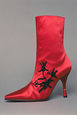 red silk satin boot with pointed toe and stiletto heel with gold ring and decorative black passementerie in Chinese style on outside