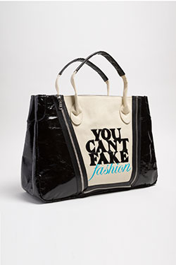 tote bag in black and dark beige with blue graphics and black vinyl appliqued letters that read YOU CAN'T FAKE FASHION