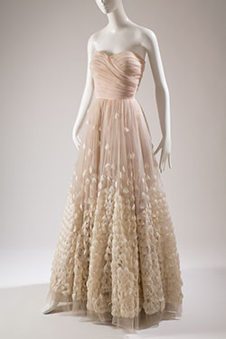 strapless florr length ballgown in pale pink tulle with white feathers hand stitched on a full circle ball room skirt and boned bodice in shirred tulle diagonally draped at front