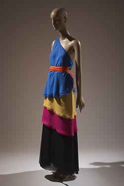 color block one shoulder tiered dress in bright blue, yellow, pink, and black with large orange bow at right side