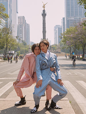 two models in pink and blue suits posing for Vogue Italia