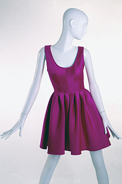 Short skating dress in neon pink scuba style neoprene knit; tank style bodice with corset seams released at waist to form box pleats