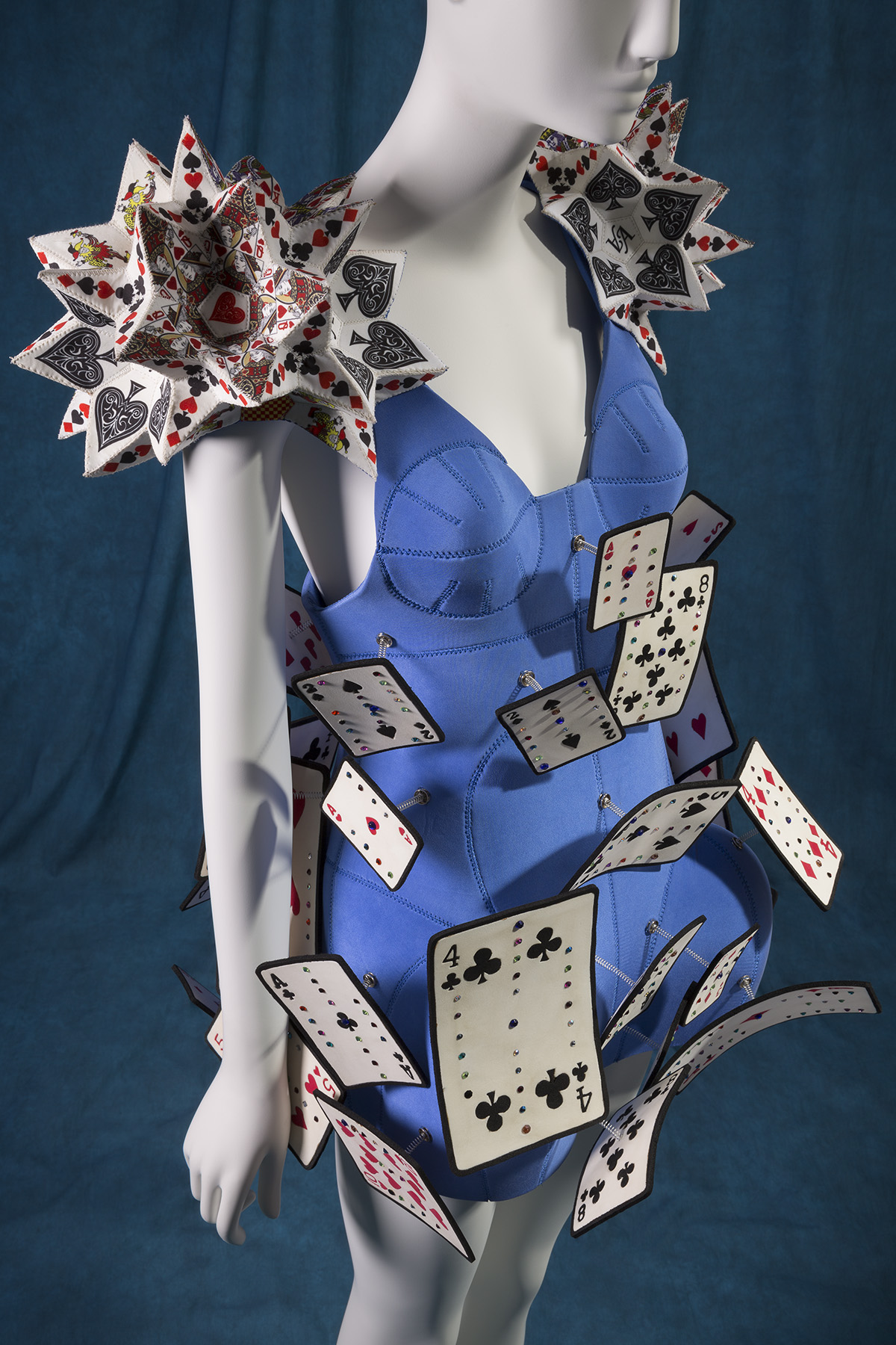 Alice in Wonderland blue mini dress with dome shaped skirt covered with playing card embellishments in white, black, red, and yellow