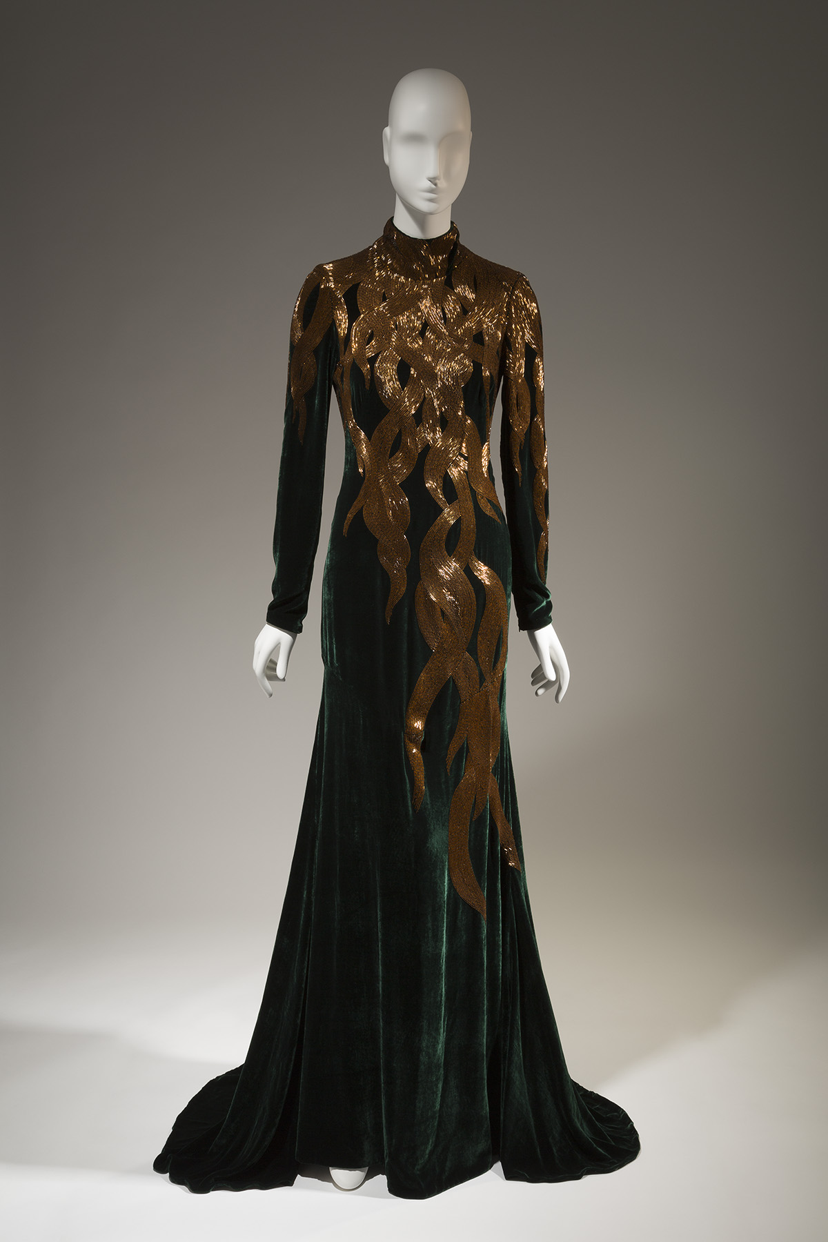 dark green velvet long sleeves evening gown with hand beaded amber-gold bugle beads in a falling hair tresses pattern at the upper dress fading to nothing at the hem