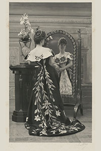 the Countess Greffulhe wearing the Lily Dress standing in front of a mirror