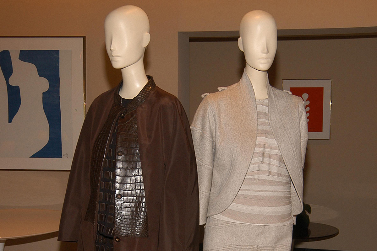 two mannequins, the left one wearing a brown ensemble with animal leather and the right one a gray ensemble