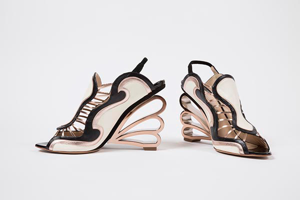 Sling back sandals with applique wave design in black, off white and metallic pink gold leather and suede, golden ribbon wave molded wedge heels, pink gold straps at front, signed by designer at soles