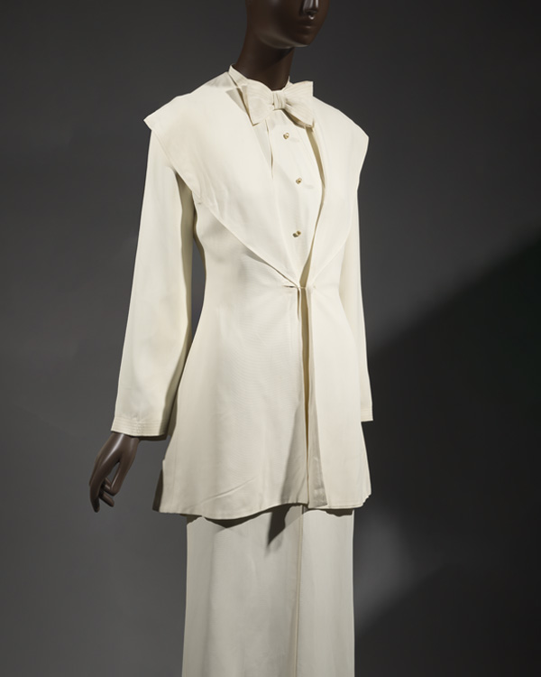 white ensemble: a whte jacket paired with a white button top and large white bowtie, and a white skirt