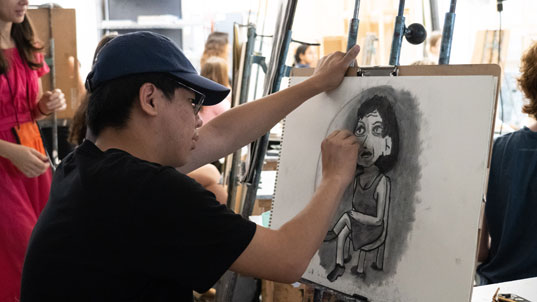 Student at easel working on a painting