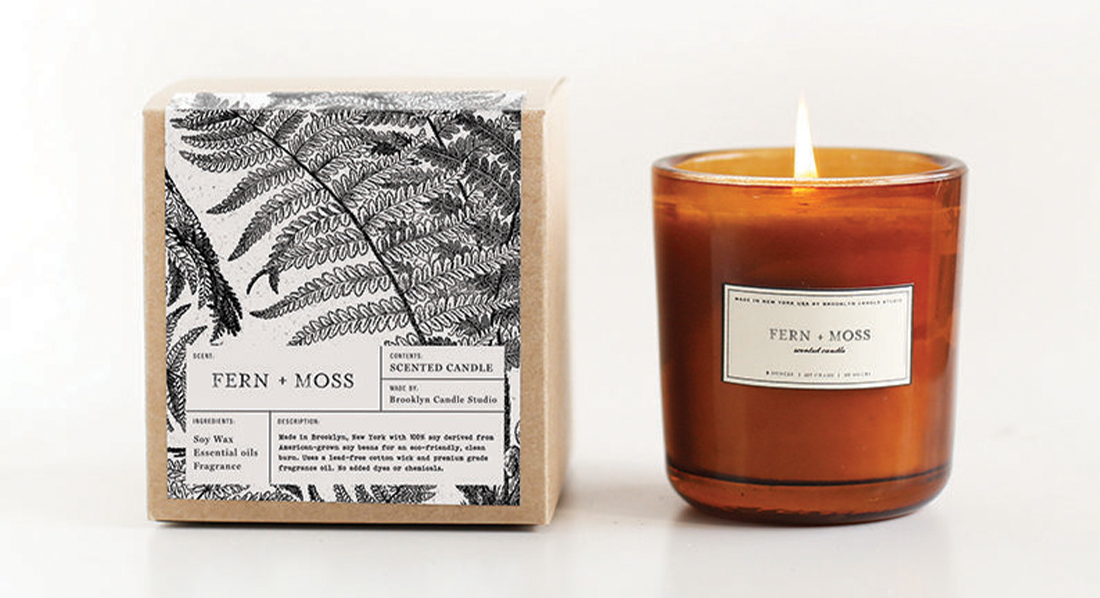 a candle and it's packaging, a cardboard box