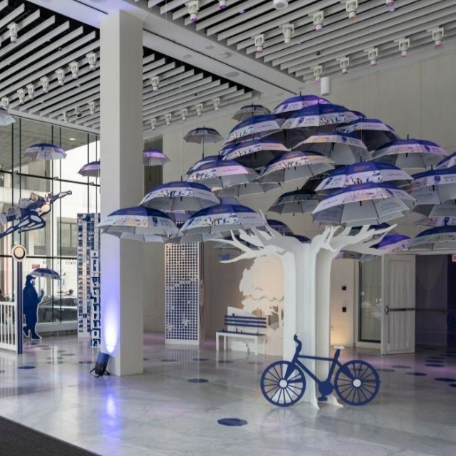 students of FIT exhibition and space design fill the gallery with cutouts pf trees, bycicles, benches, people
