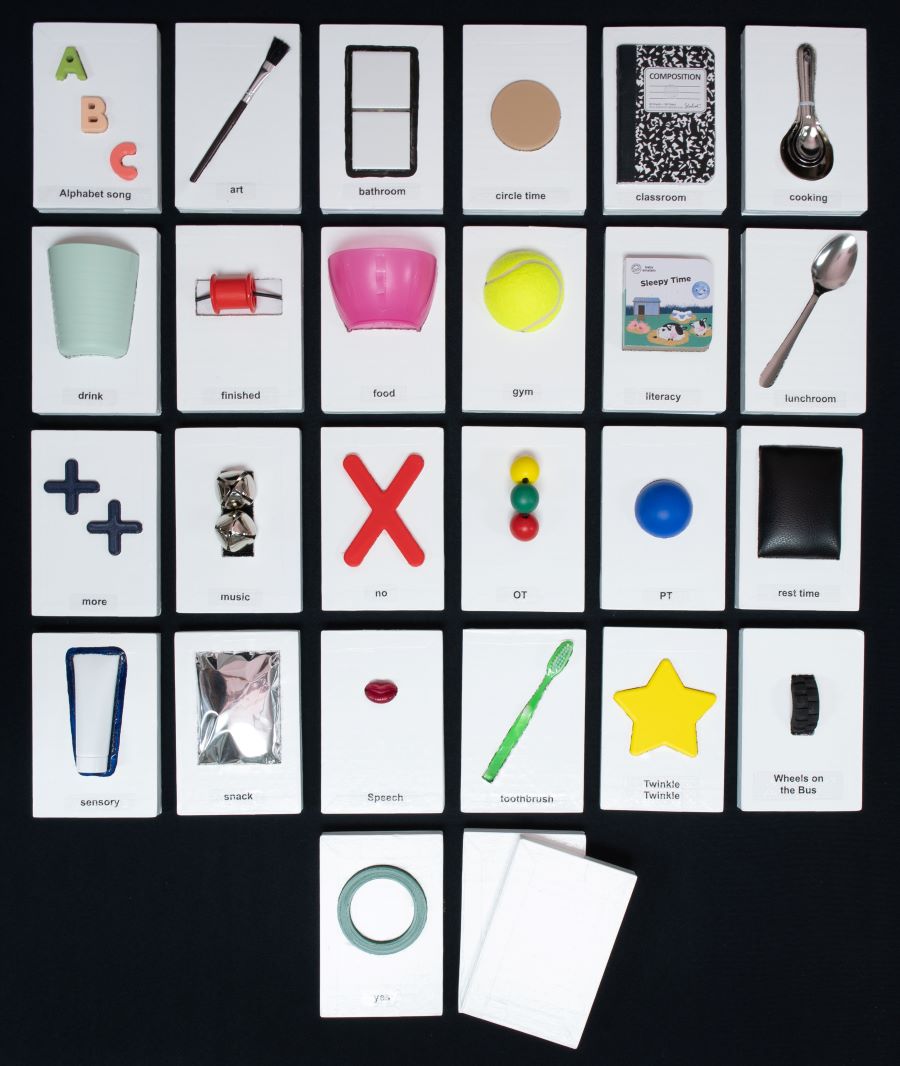 Set of handmade communication cards laid out in a grid. Each card has varied textures and it features a white background for high-contrast and enhanced visibility, showing a 3-D copy of common items, including paintbrush, notebook, spoon, cup, ball, toothbrush, star.