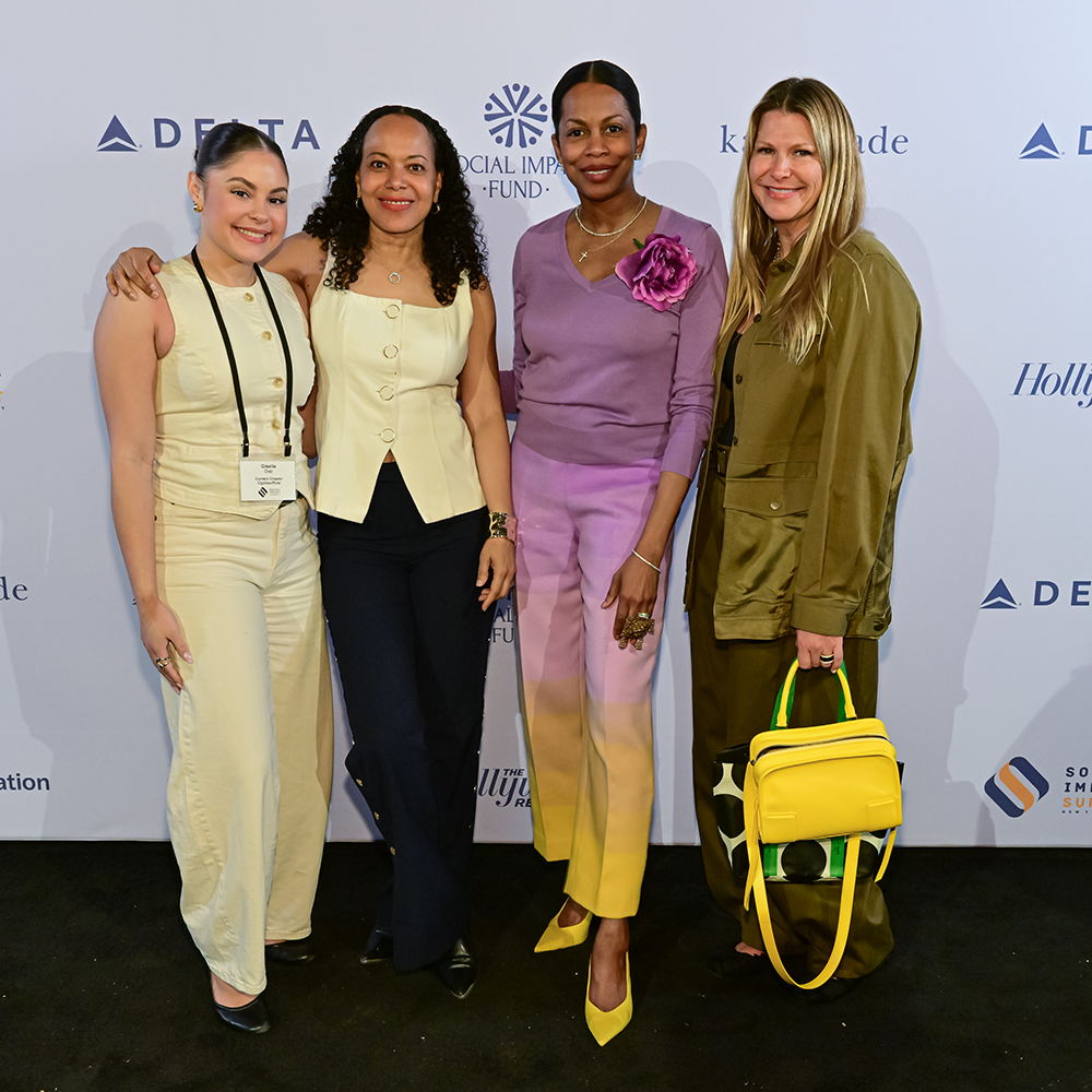 Group photo of four women smiling for a picture at the Social Impact Summit
