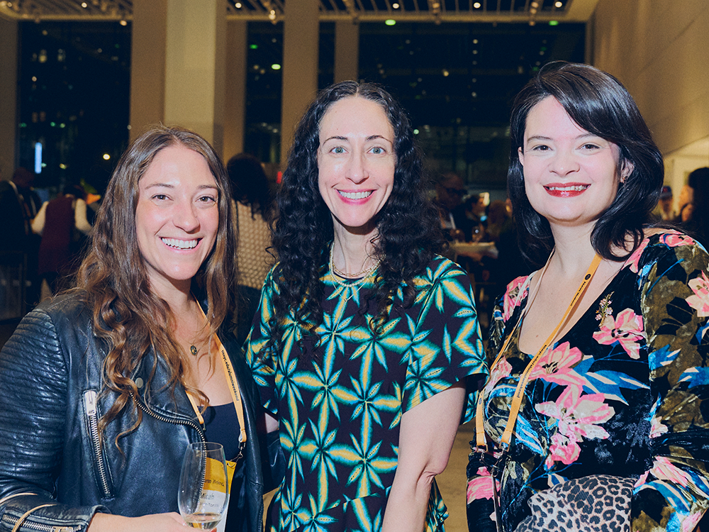 three alumni smile for a picture at the welcome reception.