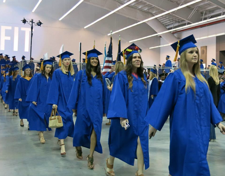 students in blue cap and gown processing in line to sit for the commencement ceremony