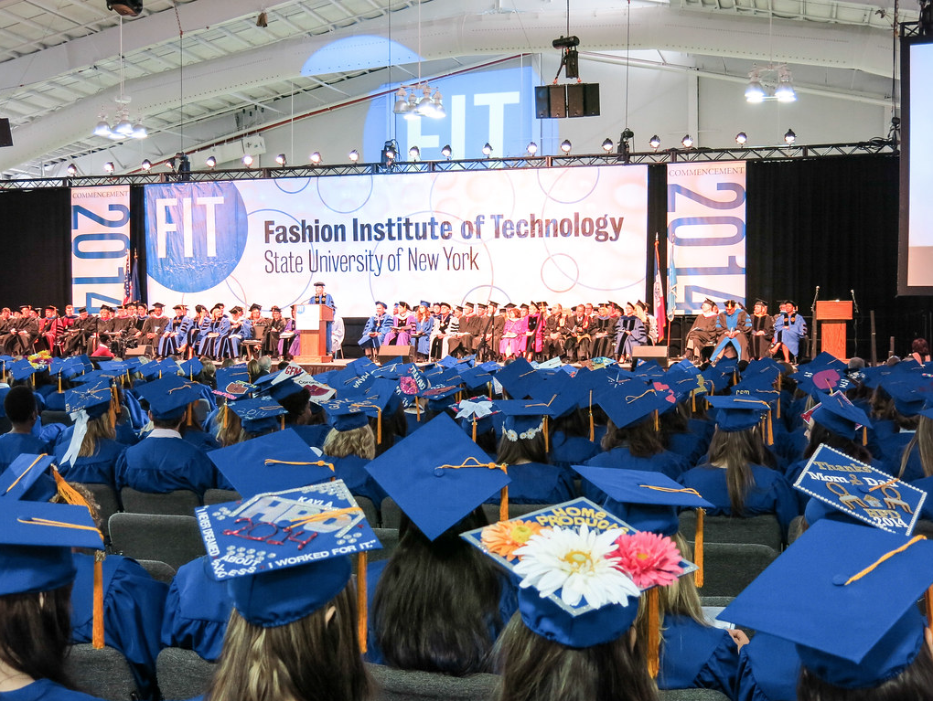 photo from the audience of caps and gowns at commencement looking at the stage