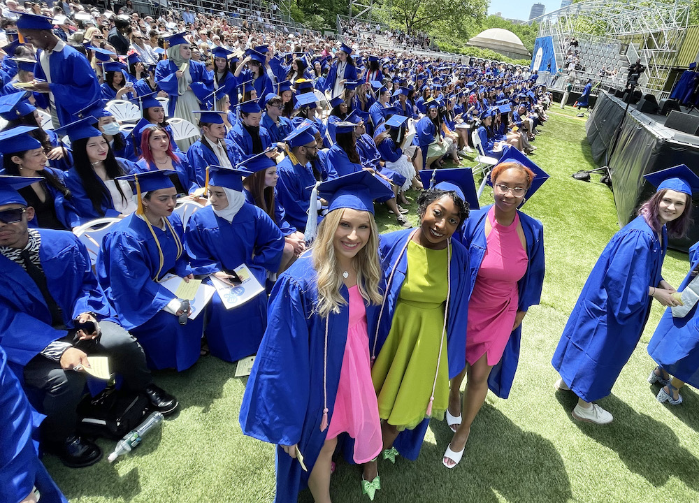 landscape photo of audience at 2022 commencement ceremony at Central Park with students in blue caps and gowns
