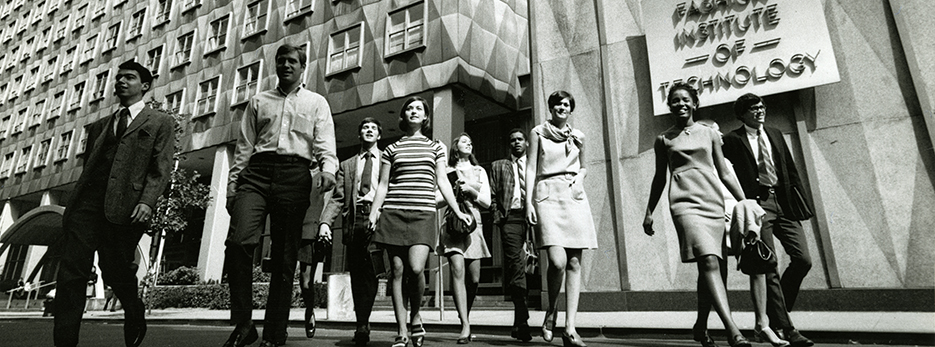 A group of alumni exit a campus building