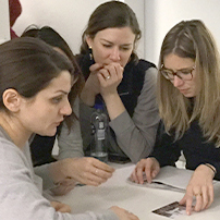 a group of female students reviewing documents