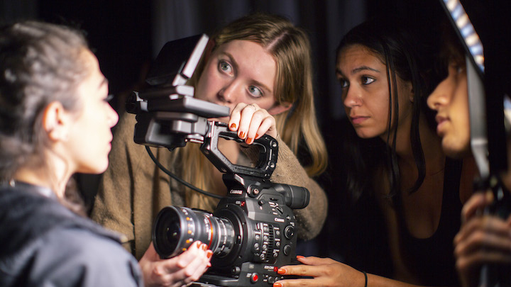 student pointing film camera at actress
