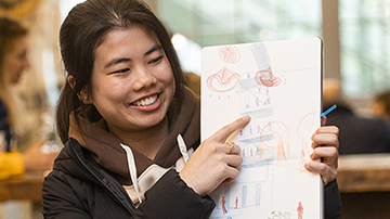 student holding up drawing