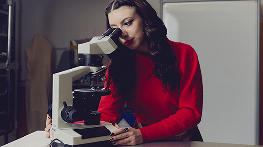 student looking into microscope
