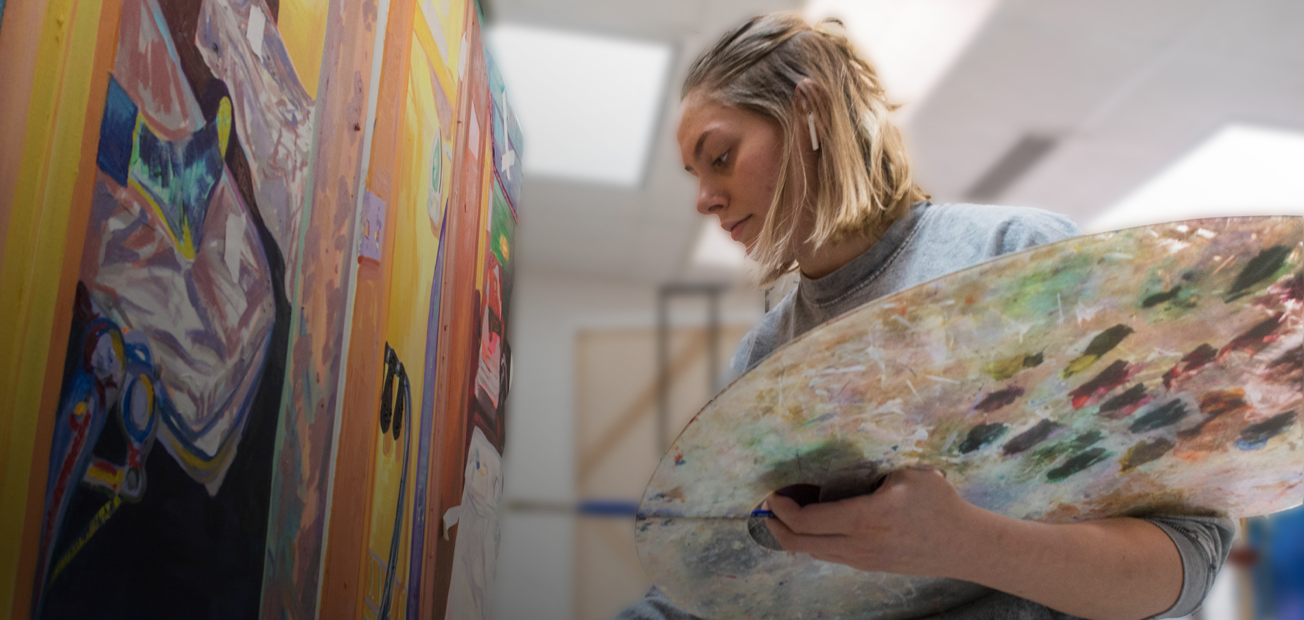 FIT student painting in Fine Arts class