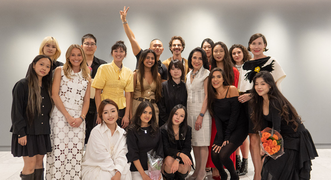 The Fashion Design MFA graduating class with Joyce F. Brown (standing center in white dress) and department chair Cathleen Sheehan (second from right).