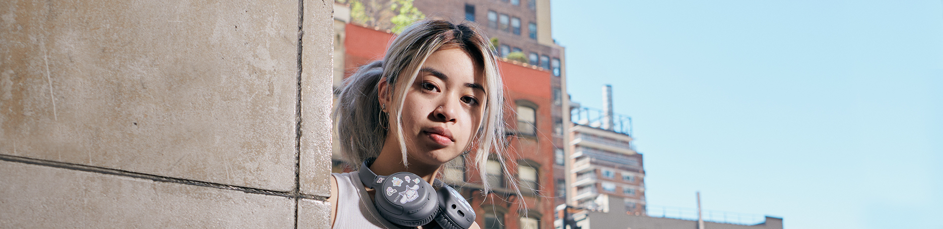 FIT student outdoors on campus with headphones around their neck