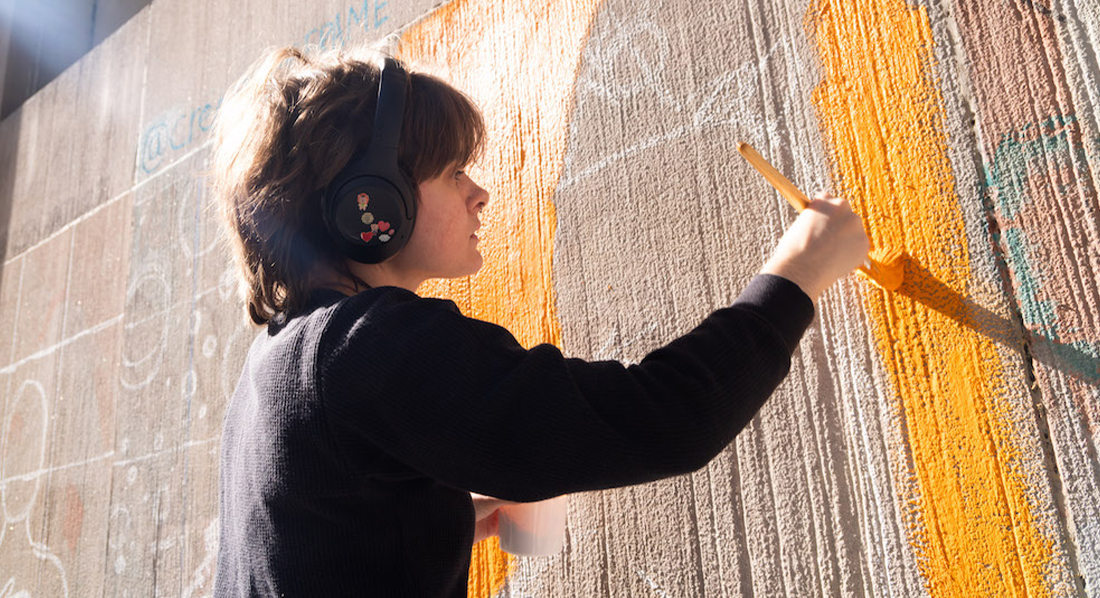 FIT illustration student painting the murals on campus