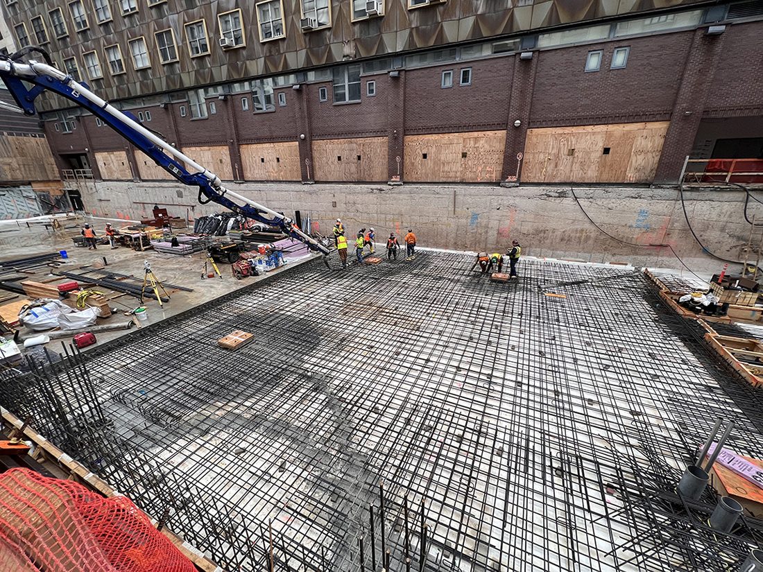 concrete being poured from truck into building foundation