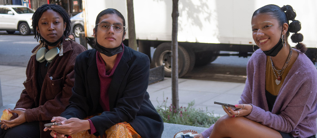 3 FIT students sitting outdoors on campus