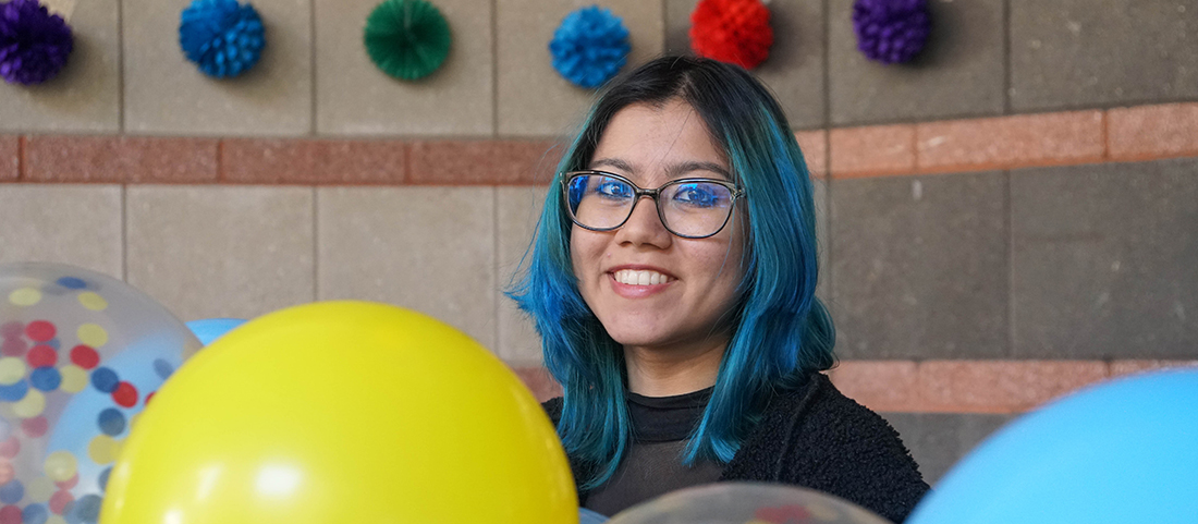 FIT student outdoors on campus with balloons for Latin Student Club event for 