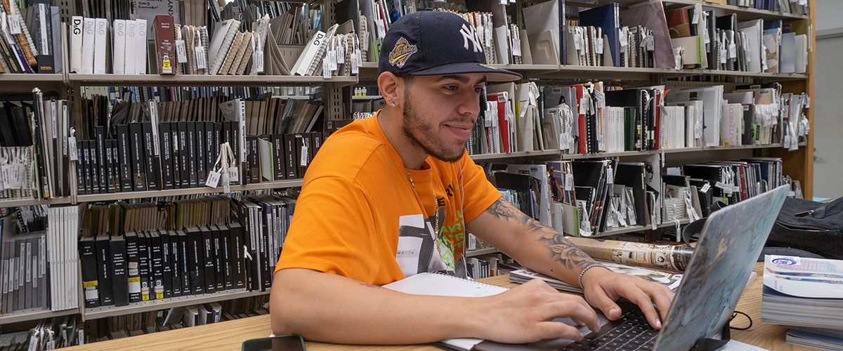 BIPOC student on computer at FIT library