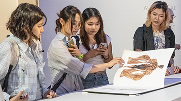 students looking at an art book