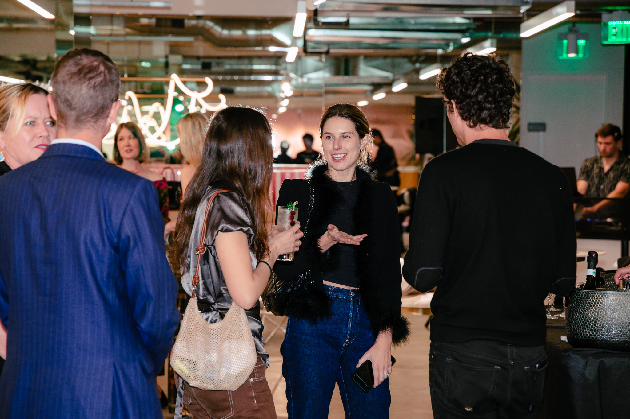 friendly crowd chats while a DJ performs a set in the background.