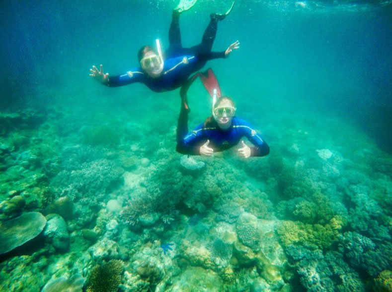 two students snorkeling at the great barrier reef.