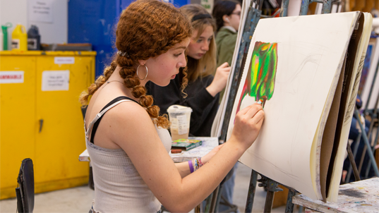 Student painting at easel