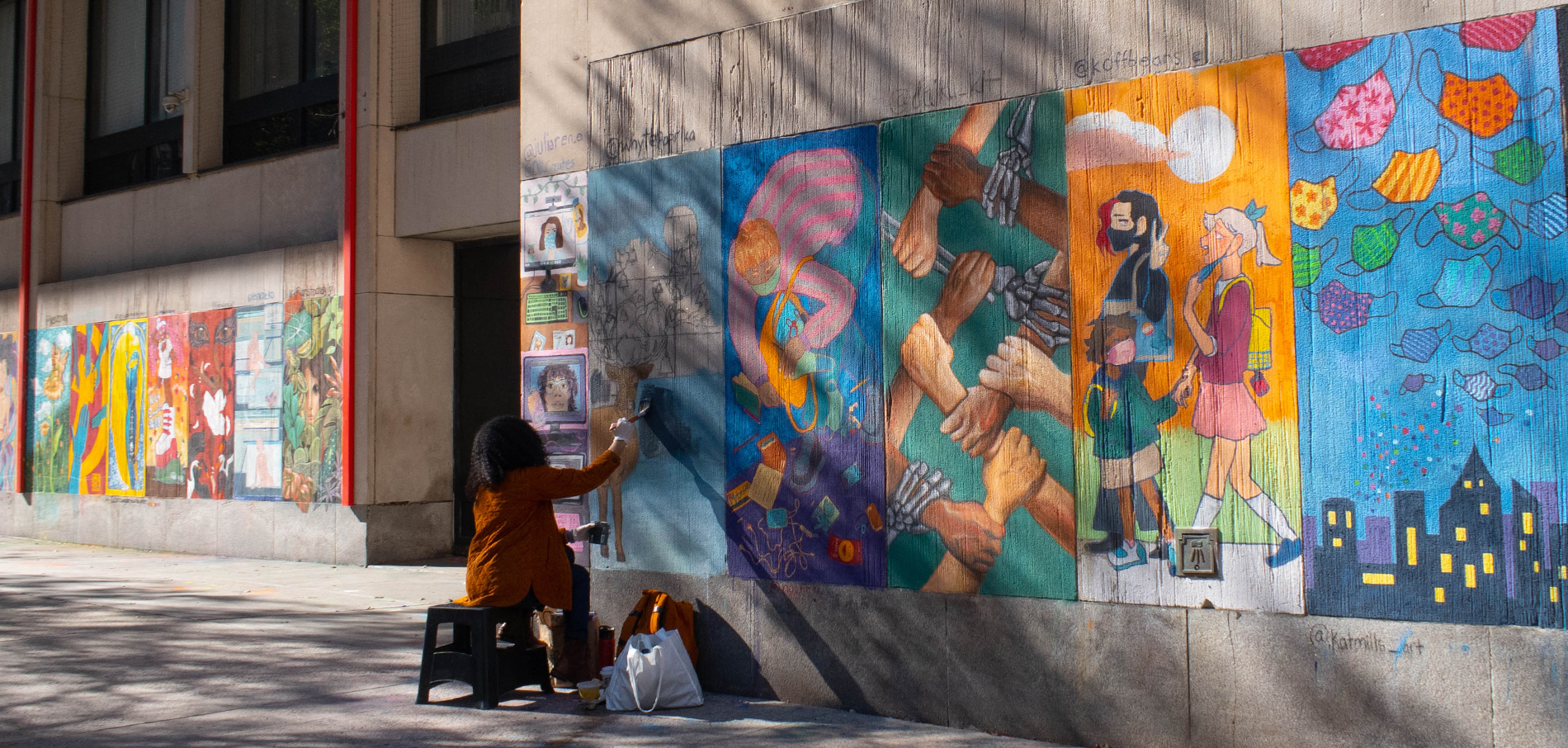Person illustrating on FIT's exterior walls using chalk