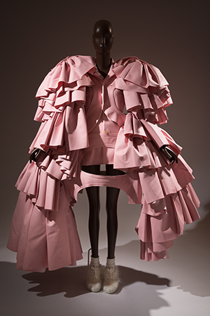 Pink dress with wide, cascading ruflles in a cape-like appearance