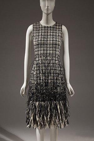 sleeveless, knee-length dress in a black and white woven plaid with feather fringe at hem