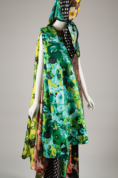 mannequin in at patterned floral and polka dot ensemble that includes a scarf covering the head 