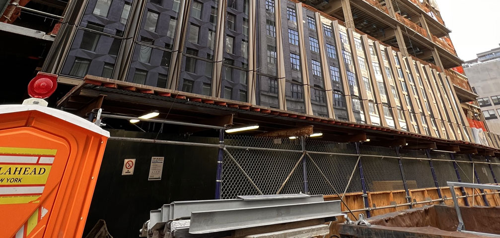 Ground-level view of new building with glass panel facade